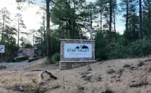Stone monument sign reading "Town of Star Valley Arizona" among tall pine trees