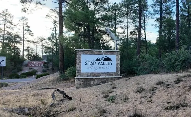 Stone monument sign reading "Town of Star Valley Arizona" among tall pine trees