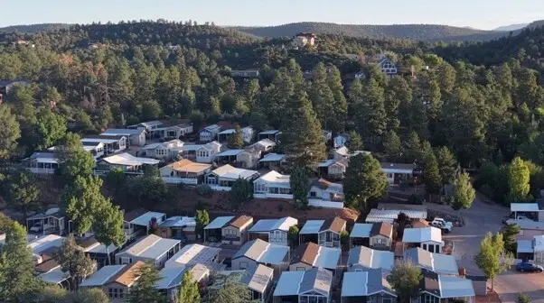 Aerial view of manufactured homes in a Star Valley park community on a pine-covered hillside