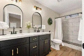 Updated primary bathroom with double vanity and custom shower